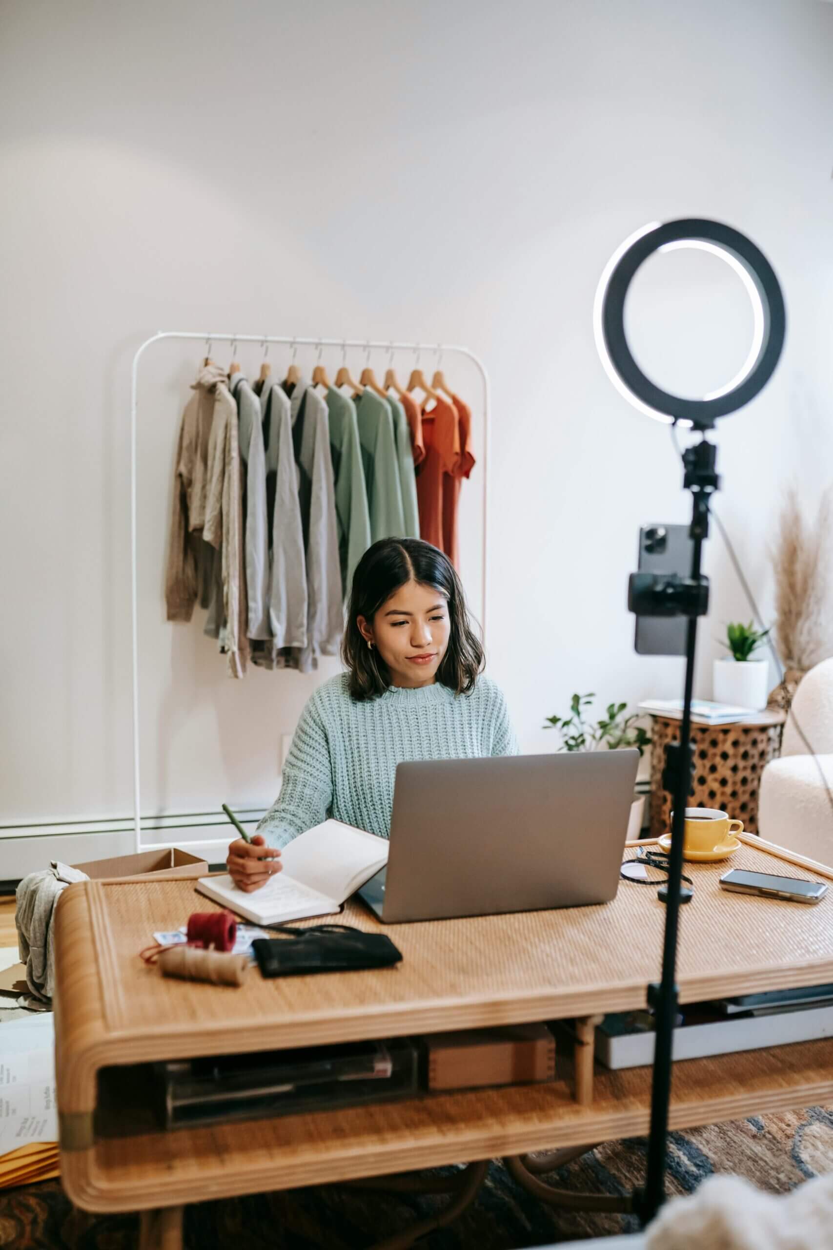 A blogger working on a laptop, surrounded by notebooks, coffee, and a camera, representing diverse monetization strategies for blogs.