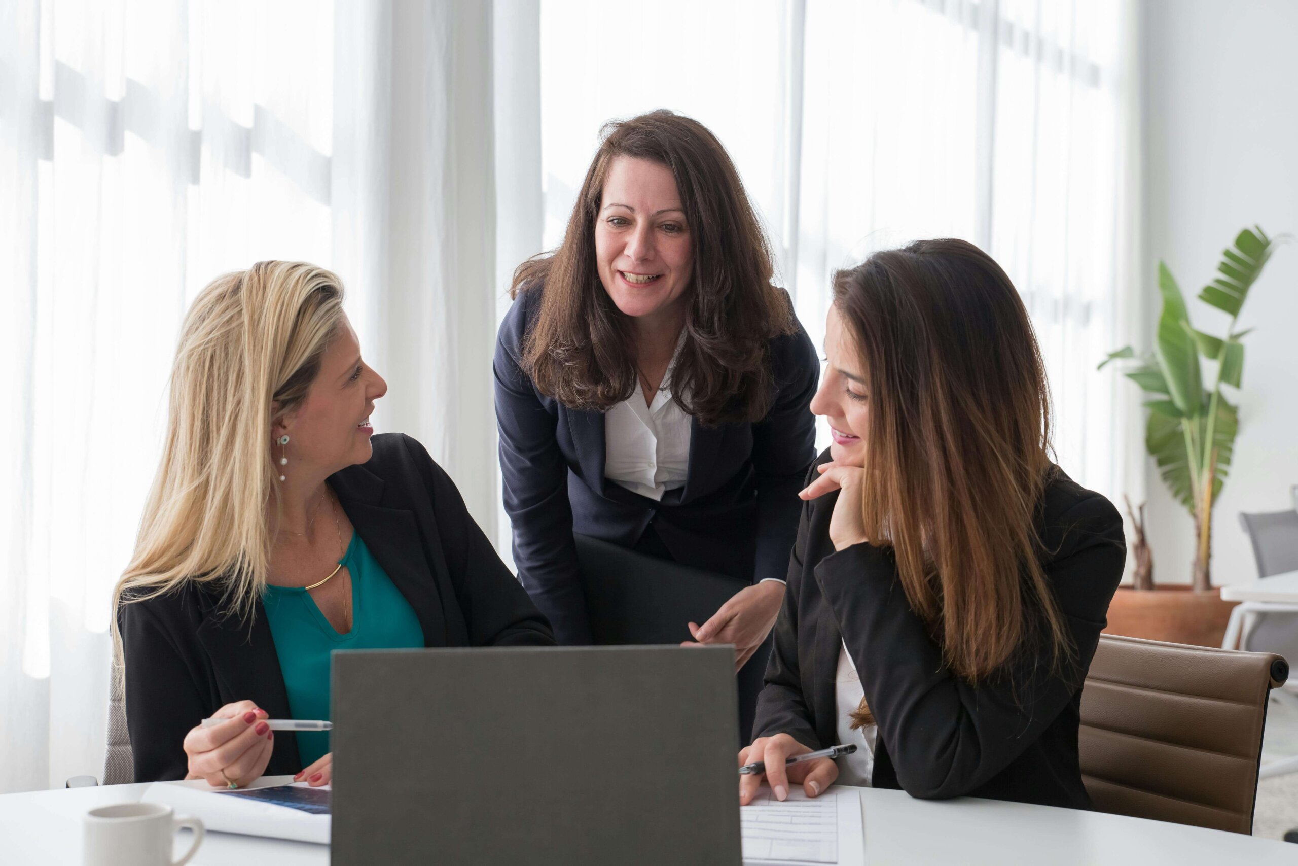 A diverse group of women in business leadership roles discussing strategies for fostering gender diversity and driving business growth