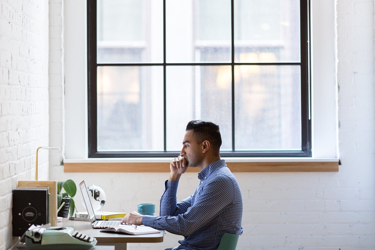 New business owner analyzing market research data on a laptop with graphs and charts to stay competitive in their industry